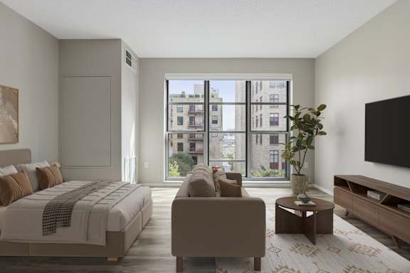 A bedroom with a large bed, a couch, a coffee table, and a flat-screen TV.