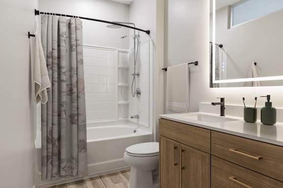 A bathroom with a toilet, sink, and shower.