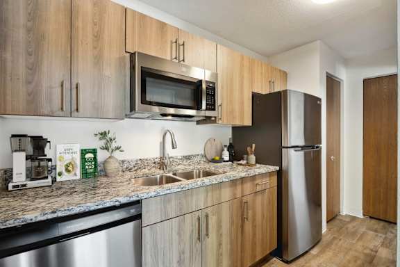 A kitchen with wooden cabinets and a stainless steel refrigerator.