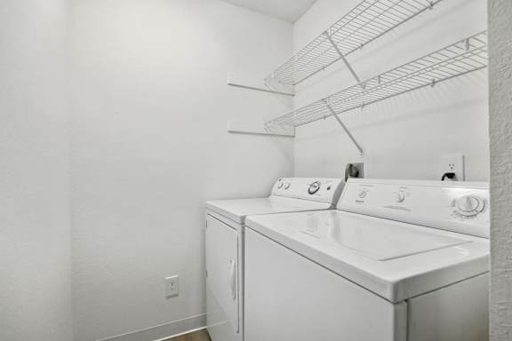 A white laundry room with a washer and dryer.
