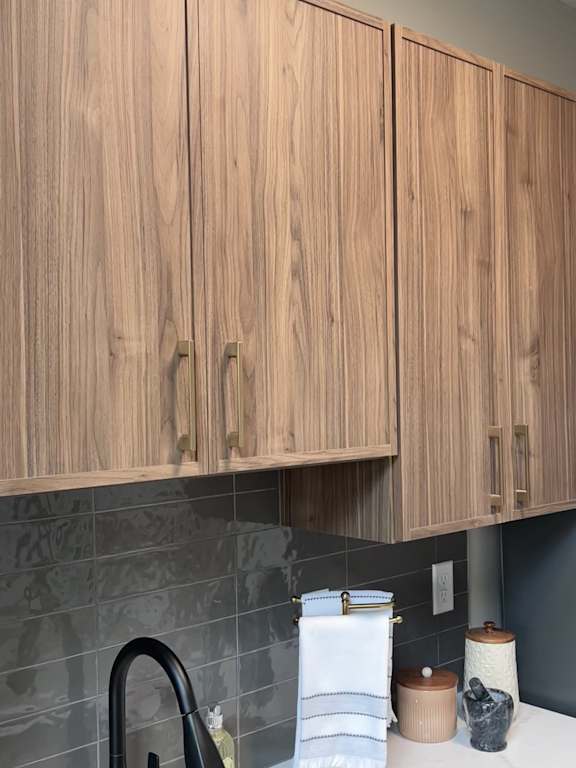 A kitchen with wooden cabinets and a black faucet.