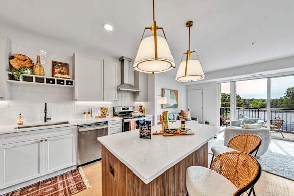 A modern kitchen with a large island and chairs.