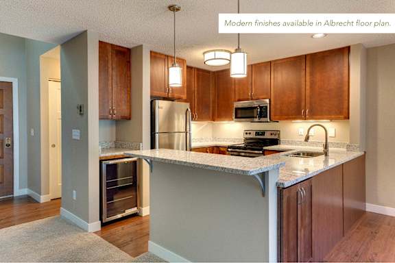 A kitchen with a refrigerator, microwave, and oven.