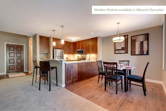 A kitchen with a dining table and chairs is available in the Albrecht floor plan.