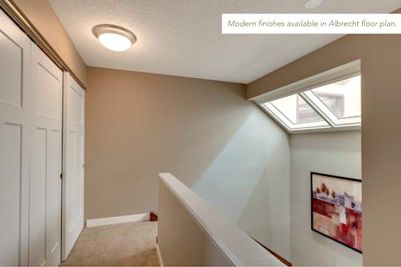 A room with a skylight and a painting on the wall.