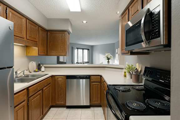 A kitchen with a stove, sink, and microwave.
