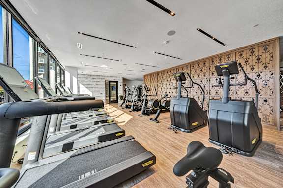 a gym with treadmills and other exercise equipment on a wood floor at The Mera, St Louis Park, MN