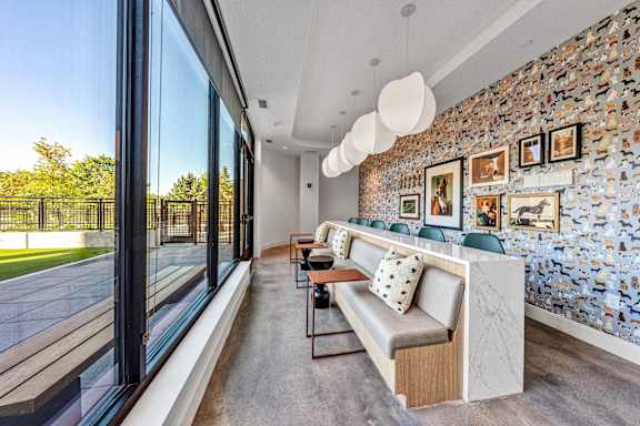 a living room with a long bar and a large window at The Mera, Minnesota