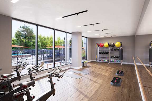 a gym with exercise equipment and large windows and a view of a pool at The Mera, St Louis Park, 55426