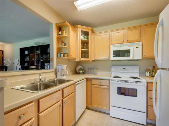 Ridge floor plan - A kitchen with wooden cabinets and white appliances at Mallard Ridge, Maple Grove