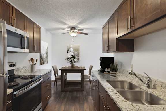 A kitchen with a table and chairs in the middle.