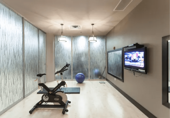 a workout room with a tv and a exercise bike