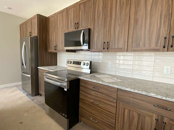 A kitchen with wooden cabinets and a granite countertop.