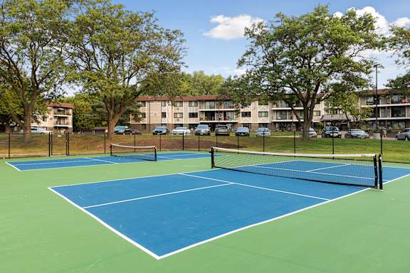 A tennis court with a net and trees in the background.