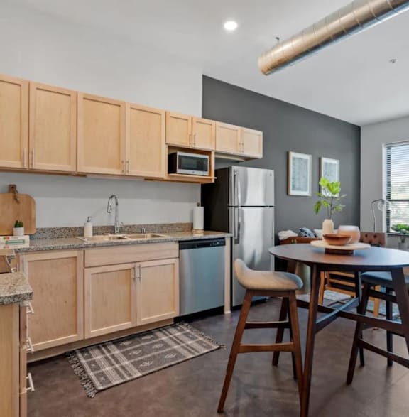 a kitchen with wooden cabinets and a table and chairs