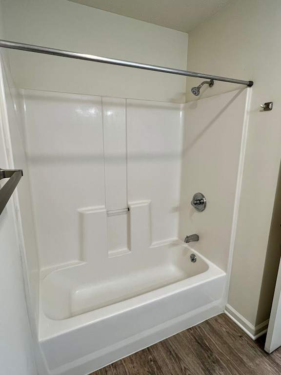 A white bathtub with a shower head and faucet.
