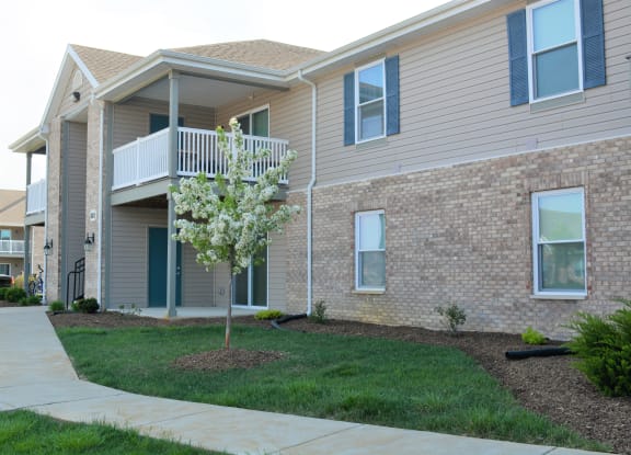 a building with a balcony and a tree in front of it at Hawthorne Properties in Lafayette, IN 47905