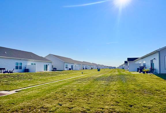 A sunny day in a residential area with houses and green lawns.