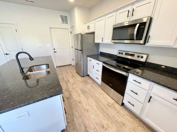 Updated kitchen with white cabinets and granite countertops at Murdock Gardens Apartments, Lafayette, IN 47904