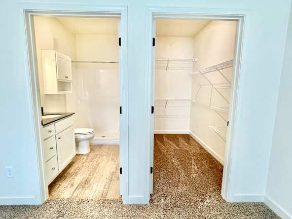 A white kitchen with a toilet and a walk in closet.at Concord Crossing, Lafayette Indiana