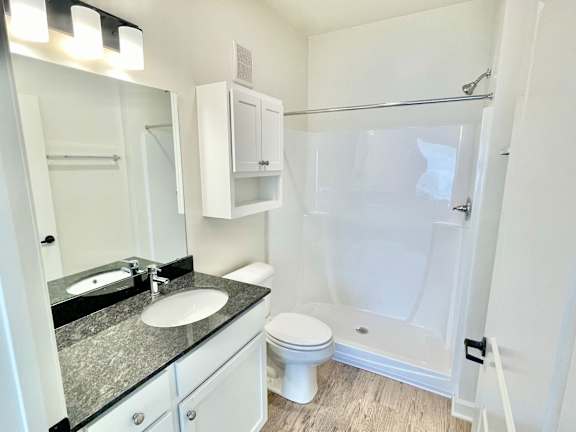 A bathroom with a sink, toilet, and shower.at Concord Crossing, Lafayette Indiana