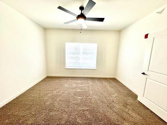 A room with a ceiling fan and a window with a white frame.at Concord Crossing, Indiana, 47909