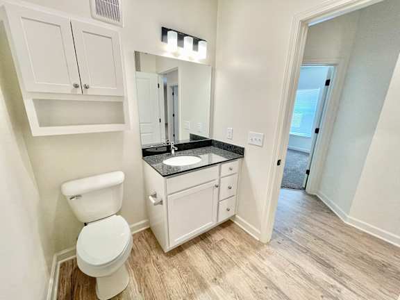 A bathroom with a white toilet and a black countertop.at Concord Crossing, Lafayette
