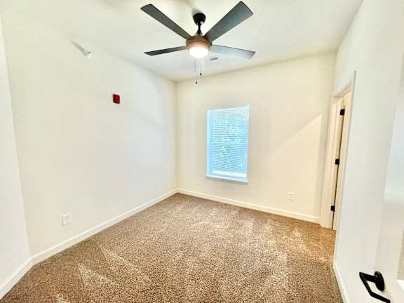 A room with a ceiling fan and carpeted floor.at Concord Crossing, Lafayette, IN