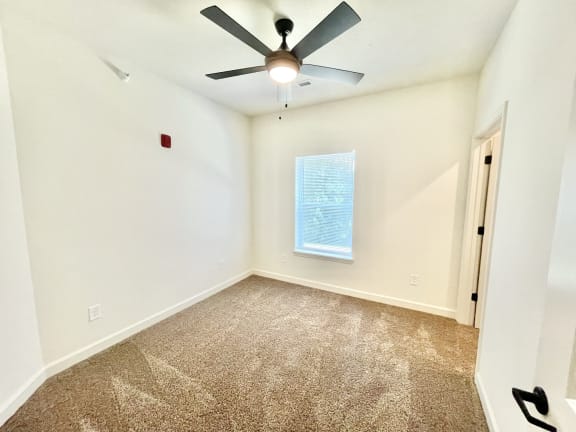 a bedroom with white walls and a ceiling fan at Murdock Gardens Apartments, Lafayette, IN 47904