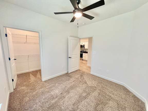 A room with a ceiling fan and carpeted floor.at Concord Crossing, Lafayette, 47909