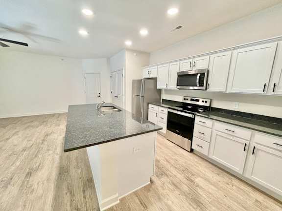 A kitchen with white cabinets and a black countertop.at Concord Crossing, Lafayette