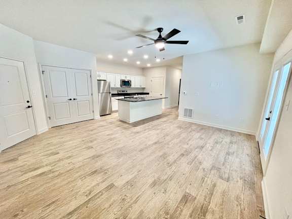 A kitchen with a fan and wooden flooring.at Concord Crossing, Indiana, 47909