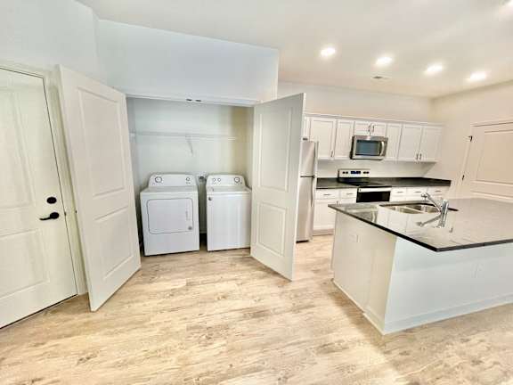 A kitchen with white appliances and cabinets.at Concord Crossing, Indiana
