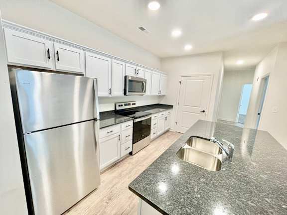 A kitchen with a stainless steel refrigerator, microwave, and oven.at Concord Crossing, Lafayette Indiana