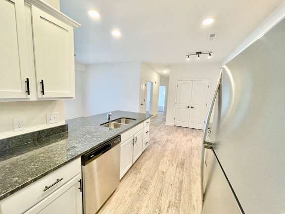 A kitchen with white cabinets and a black countertop.at Concord Crossing, Lafayette, IN 47909
