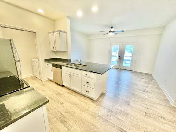 A kitchen with a black countertop and white cabinets.at Concord Crossing, Lafayette