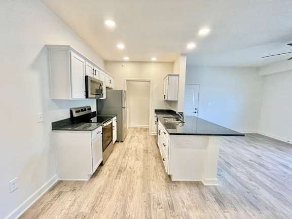 A kitchen with white cabinets and a black countertop.at Concord Crossing, Lafayette, IN 47909
