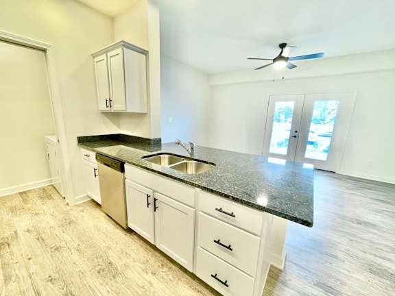 A kitchen with a sink, cabinets, and a ceiling fan.at Concord Crossing, Lafayette Indiana