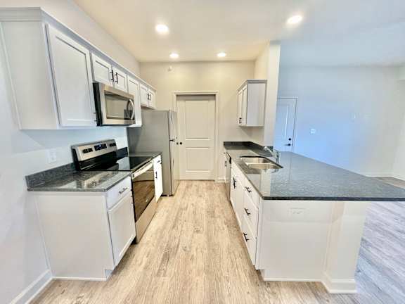 A kitchen with white cabinets and a black countertop.at Concord Crossing, Lafayette, IN