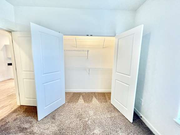 A white door is open to a room with a carpeted floor.at Concord Crossing, Lafayette