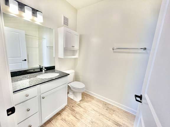 A bathroom with a toilet, sink, and medicine cabinet.at Concord Crossing, Lafayette Indiana