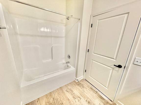 A white bathroom with a tub and a door.at Concord Crossing, Indiana, 47909