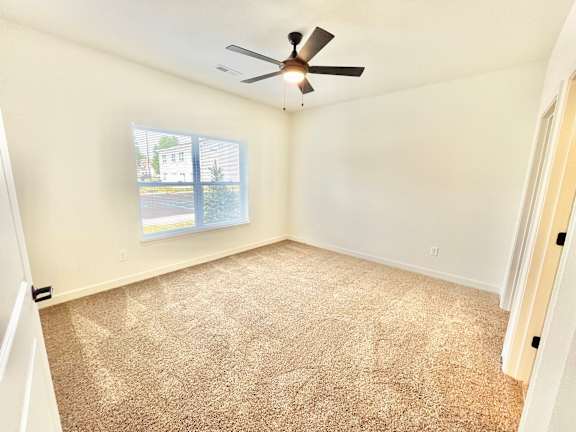 A room with a ceiling fan and carpeted floor.at Concord Crossing, Lafayette, IN 47909