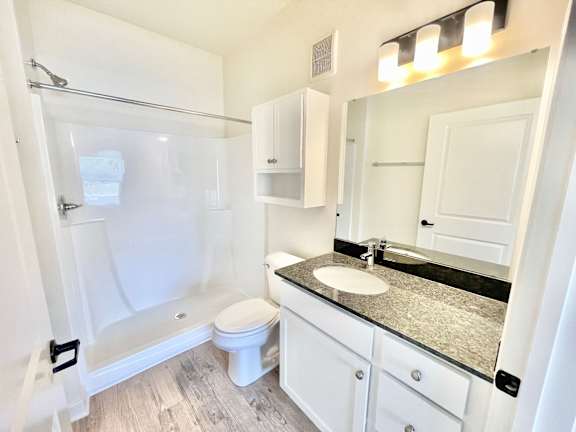 A white bathroom with a sink, toilet and shower.at Concord Crossing, Lafayette