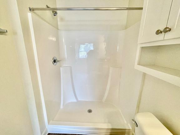 A white bathroom with a walk-in shower and a toilet.at Concord Crossing, Lafayette, IN 47909