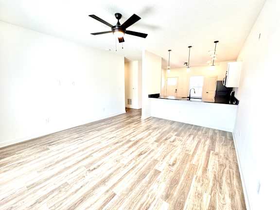 A room with a ceiling fan and wooden flooring.at Concord Crossing, Lafayette, IN 47909