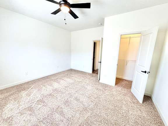 A room with a ceiling fan and carpeted floor.at Concord Crossing, Lafayette, IN