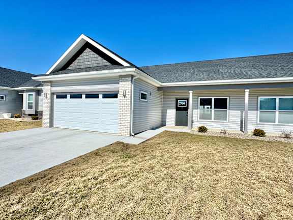 A house with a grey garage door and a black roof.at Concord Crossing, Indiana