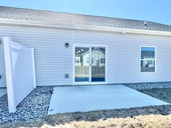 A house with a grey siding and a white fence.at Concord Crossing, Lafayette, 47909