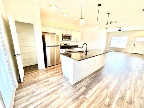A modern kitchen with a wooden floor and stainless steel appliances.at Concord Crossing, Lafayette